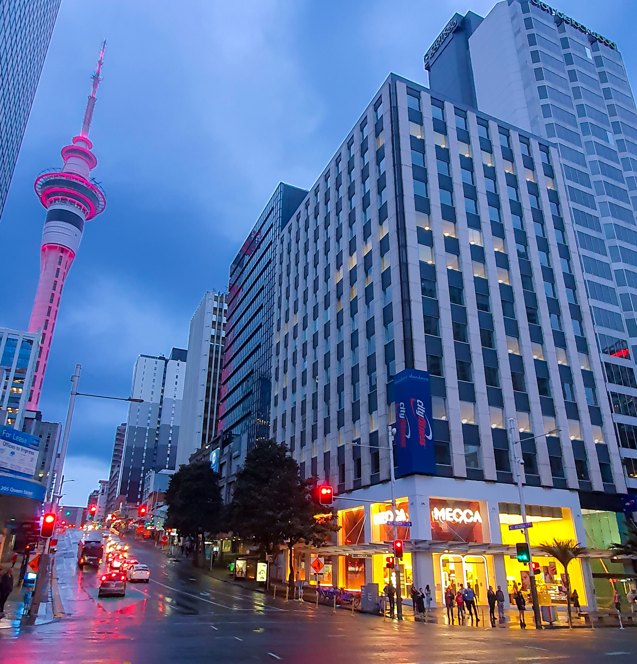 Picture of a building at 203 Queen Street and sky tower in the evening 