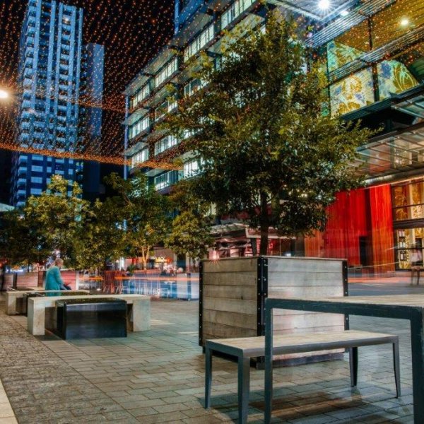 Federal Street at night in Auckland City Centre, SkyCity Convention Centre and restaurants alone the laneway with outdoor seating and dining, traffic, fairy lights, and tower blocks