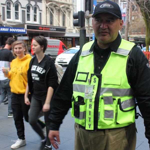 CityWatch team member JR John on Queen Street in Auckland City Centre among pedestrians, retail, green spaces, tourists, heritage buildings, 