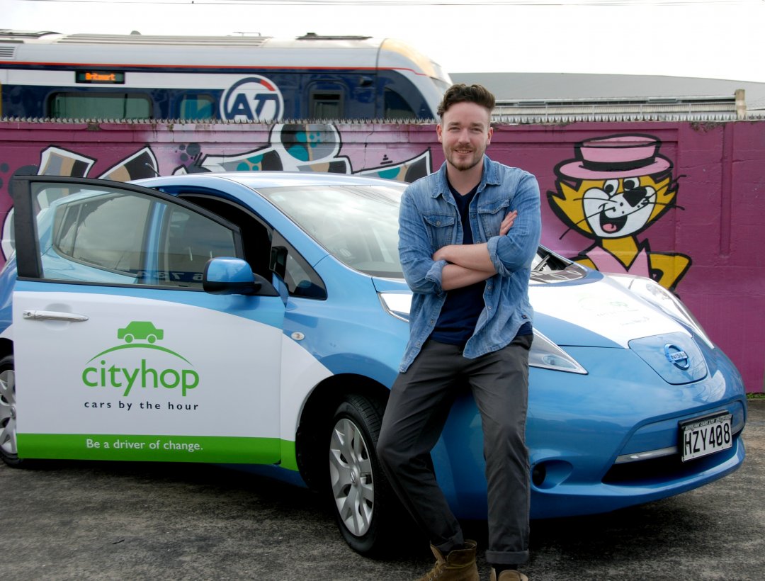 Cityhop General Manager Ben Carter with a Nissan Leaf EV from their fleet. Image: Cityhop.